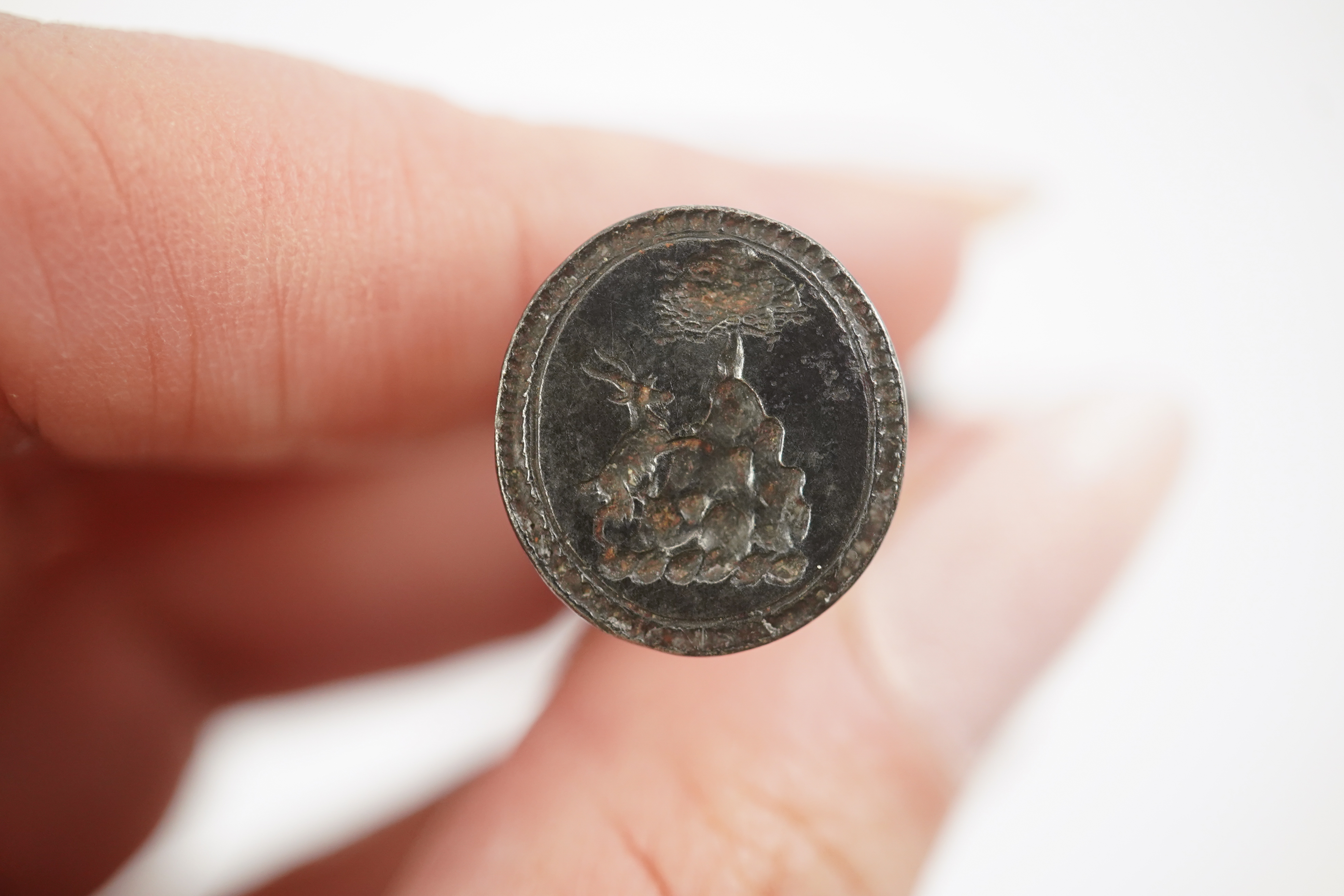 An early 18th century silver and gold signet ring, embossed with an armorial, size R, together with a steel double ended fob seal